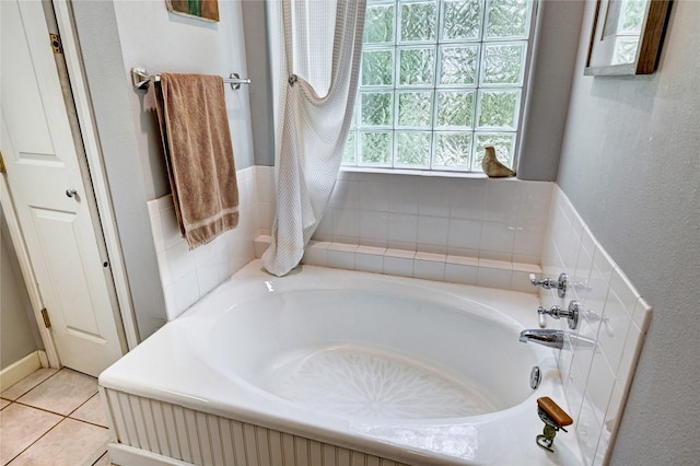 bathroom featuring a garden tub, tile patterned flooring, and a textured wall