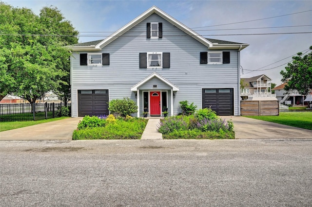 view of front facade featuring fence, concrete driveway, and an attached garage