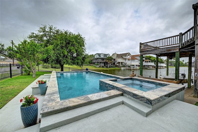 view of pool featuring a deck with water view, a patio area, and a pool with connected hot tub
