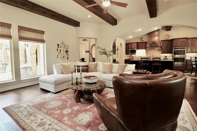living room with arched walkways, ceiling fan, beamed ceiling, wood finished floors, and recessed lighting