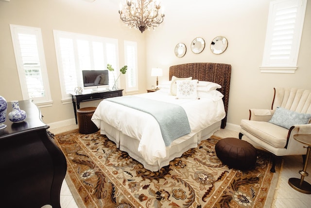 bedroom with baseboards and a chandelier