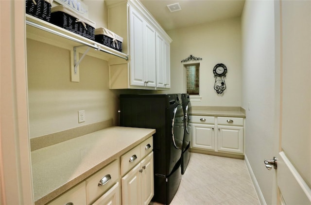 washroom with cabinet space, washing machine and clothes dryer, and baseboards