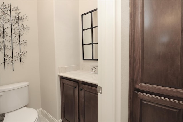 half bathroom with vanity and toilet