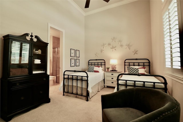 bedroom with ornamental molding, light colored carpet, ensuite bathroom, and ceiling fan