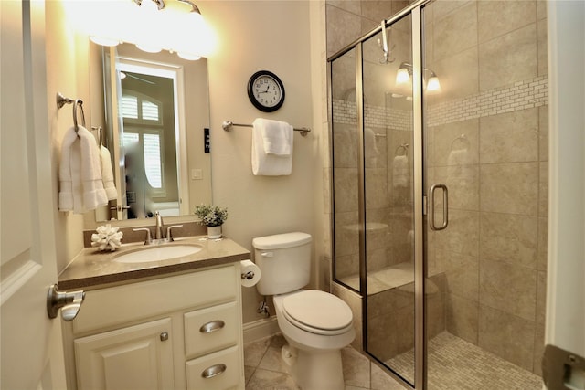 full bath with a shower stall, toilet, vanity, tile patterned floors, and baseboards