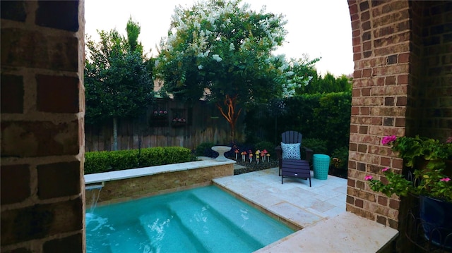 view of swimming pool featuring fence and a patio area