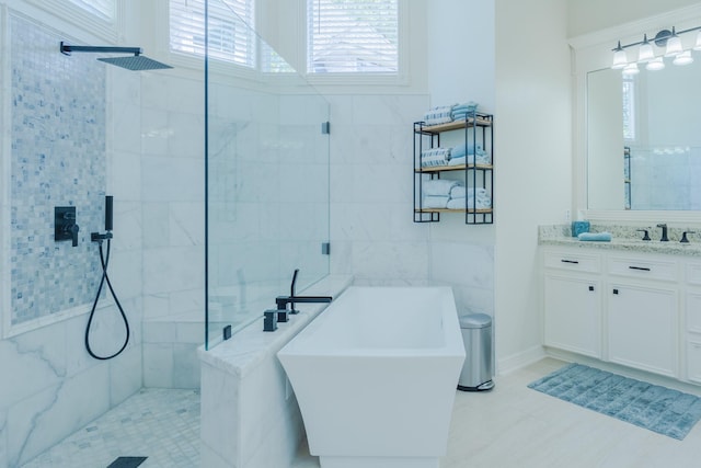 34 S Taylor Point Dr, The Woodlands, TX 77382 - bathroom with plenty of natural light, vanity, walk in shower, a freestanding tub, and tile walls
