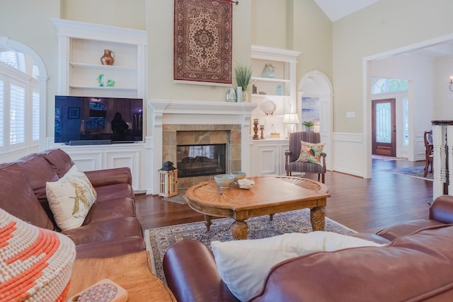 34 S Taylor Point Dr, The Woodlands, TX 77382 - living room with high vaulted ceiling, built in features, healthy amount of natural light, wood finished floors, and a tiled fireplace