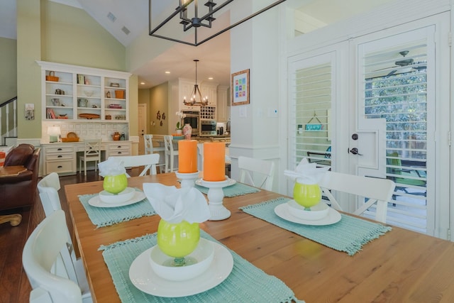 34 S Taylor Point Dr, The Woodlands, TX 77382 - dining room with a chandelier, lofted ceiling, wood finished floors, and stairs