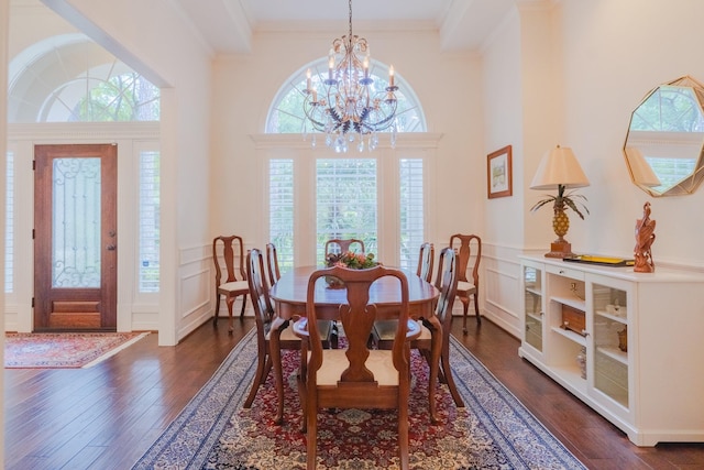 34 S Taylor Point Dr, The Woodlands, TX 77382 - dining room with dark wood-type flooring, a decorative wall, a chandelier, a wainscoted wall, and crown molding