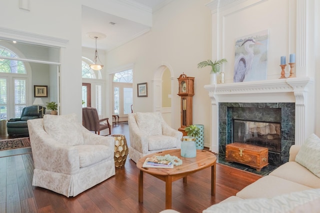 34 S Taylor Point Dr, The Woodlands, TX 77382 - living room with healthy amount of natural light, crown molding, a fireplace, dark wood finished floors, and arched walkways