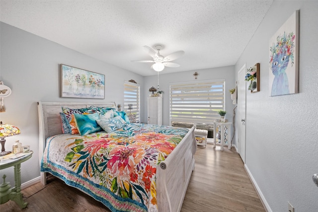 79 Lakeview Vlg, Conroe, TX 77356 - bedroom with baseboards, a textured ceiling, wood finished floors, a ceiling fan, and a textured wall