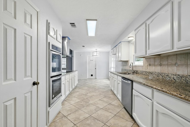 12318 Amado Dr, Houston, TX 77065 - kitchen with a sink, appliances with stainless steel finishes, white cabinetry, backsplash, and stone countertops