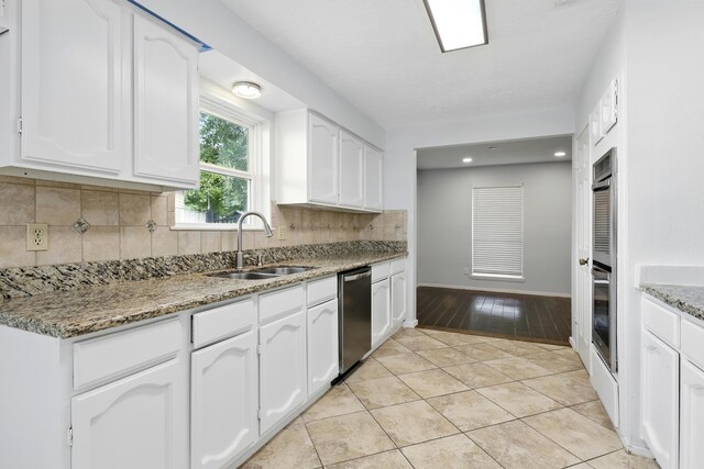12318 Amado Dr, Houston, TX 77065 - kitchen featuring a sink, stainless steel appliances, white cabinetry, tasteful backsplash, and recessed lighting