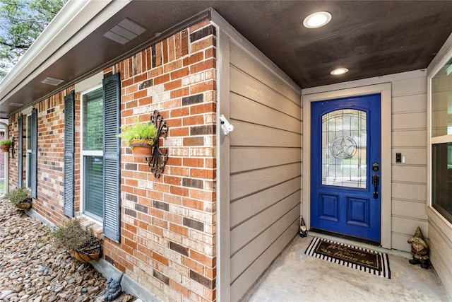 entrance to property featuring brick siding