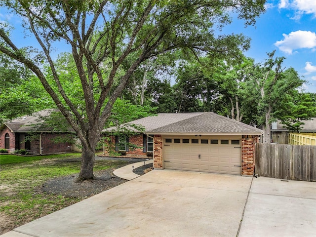 ranch-style house featuring brick siding, fence, concrete driveway, an attached garage, and roof with shingles