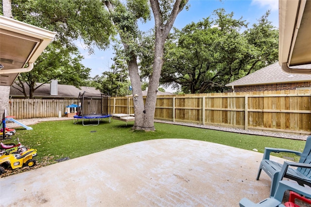 view of yard featuring a patio and a trampoline