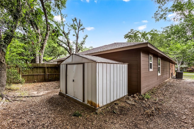 view of shed featuring fence and cooling unit