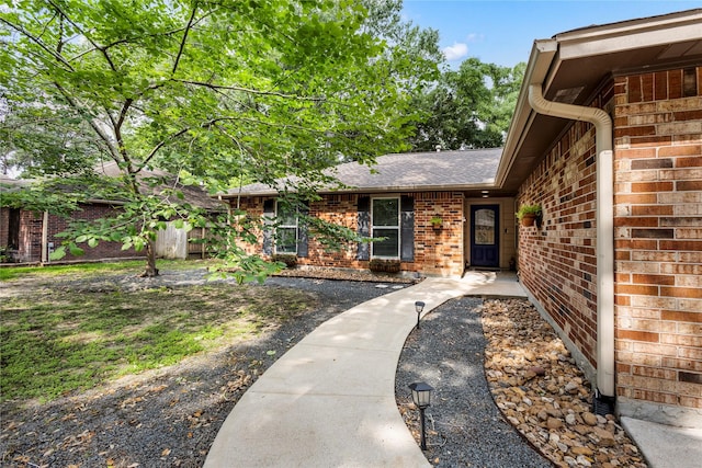 view of front of home featuring brick siding and a shingled roof