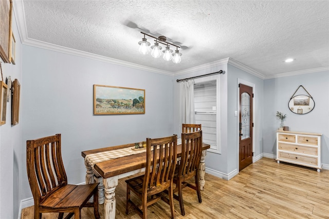 dining area with a textured ceiling, light wood-style floors, ornamental molding, baseboards, and recessed lighting