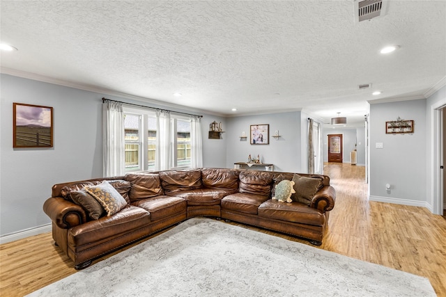 living room with light wood-type flooring, crown molding, recessed lighting, baseboards, and a textured ceiling