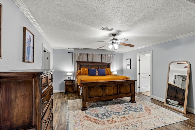 bedroom featuring wood finished floors, baseboards, ornamental molding, ceiling fan, and a textured ceiling