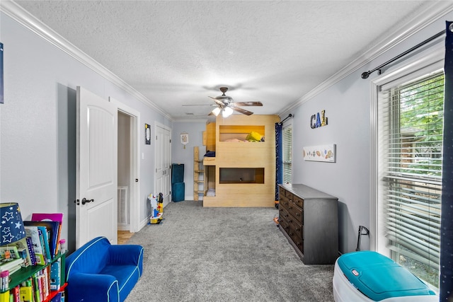 recreation room with carpet, ornamental molding, ceiling fan, and a textured ceiling