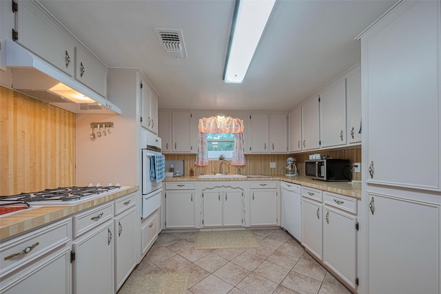 1745 15th St, Hempstead, TX 77445 - kitchen with white appliances, a sink, a warming drawer, under cabinet range hood, and light countertops