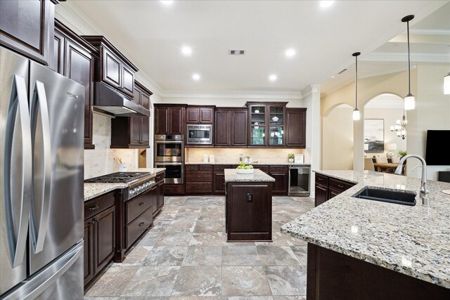 kitchen featuring stainless steel appliances, a sink, a kitchen island, crown molding, and a chandelier