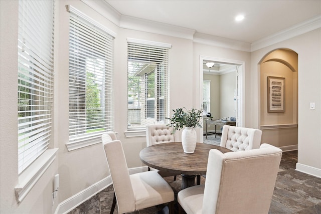dining area with ornamental molding, baseboards, and arched walkways
