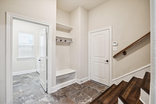 mudroom featuring baseboards and stone finish flooring
