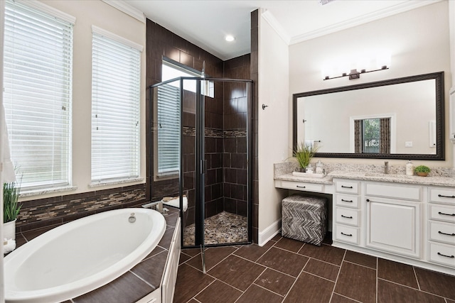 bathroom featuring healthy amount of natural light, a shower stall, a garden tub, vanity, and crown molding