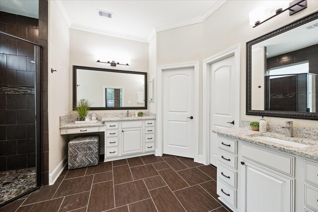 bathroom with a stall shower, two vanities, crown molding, healthy amount of natural light, and baseboards