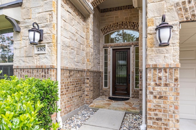 property entrance featuring stone siding, brick siding, and central air condition unit