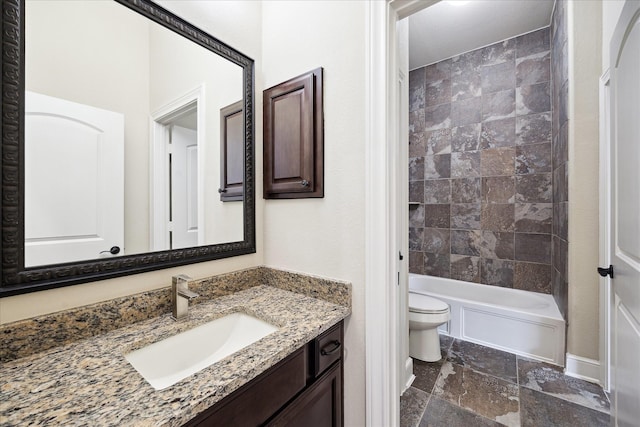 full bathroom featuring toilet, vanity, stone tile floors, and bathing tub / shower combination