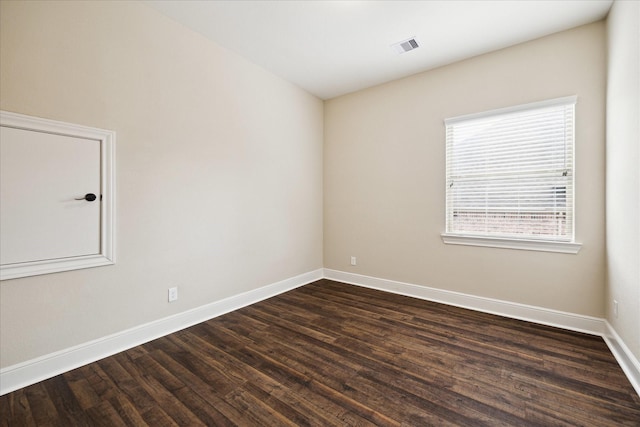 empty room featuring dark wood-style floors and baseboards