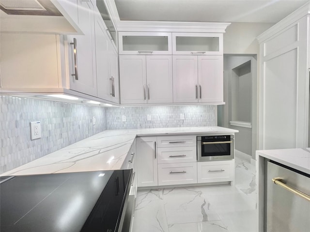1156 Rd 6604, Dayton, TX 77535 - kitchen with stainless steel oven, light stone countertops, decorative backsplash, light marble finish flooring, and glass insert cabinets