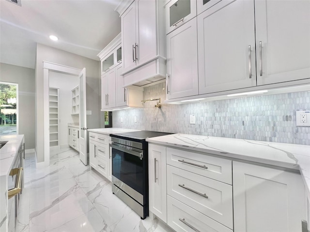 1156 Rd 6604, Dayton, TX 77535 - kitchen featuring electric range, light marble finish floors, light stone countertops, white cabinetry, and backsplash