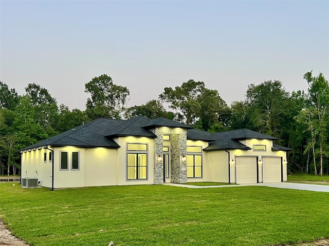 1156 Rd 6604, Dayton, TX 77535 - view of front facade featuring an attached garage, a front yard, driveway, central air condition unit, and stucco siding