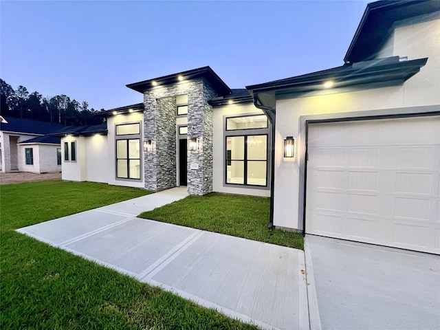 1156 Rd 6604, Dayton, TX 77535 - view of front of home with a garage, a front yard, stucco siding, and stone siding
