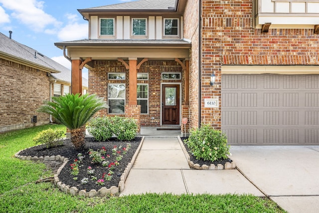 entrance to property with brick siding, driveway, an attached garage, stucco siding, and roof with shingles