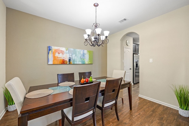 dining room with arched walkways, dark wood-style flooring, baseboards, and a chandelier
