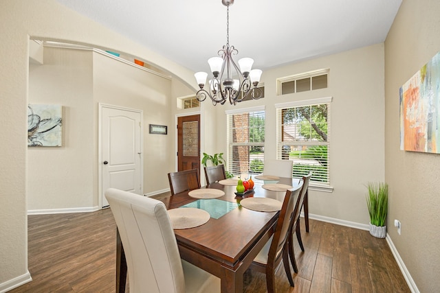 dining space featuring wood finished floors, a chandelier, and baseboards