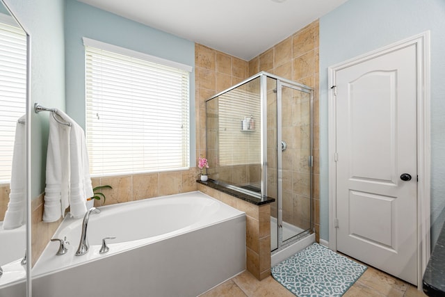 bathroom with a stall shower and a bath