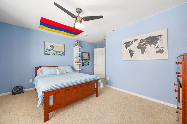 bedroom with light colored carpet, a ceiling fan, and baseboards