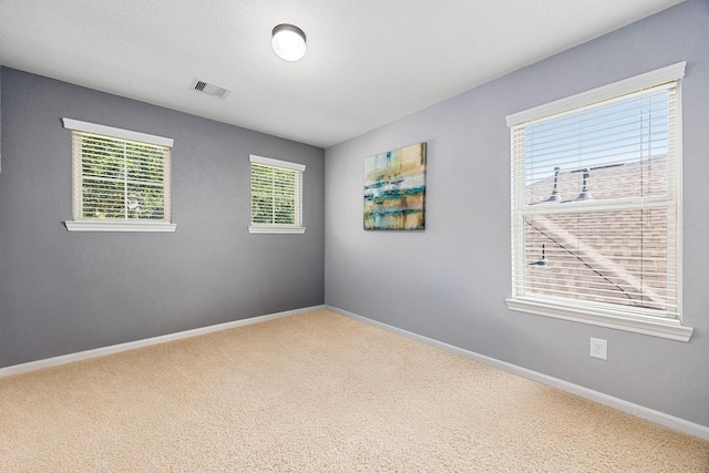 carpeted empty room featuring baseboards