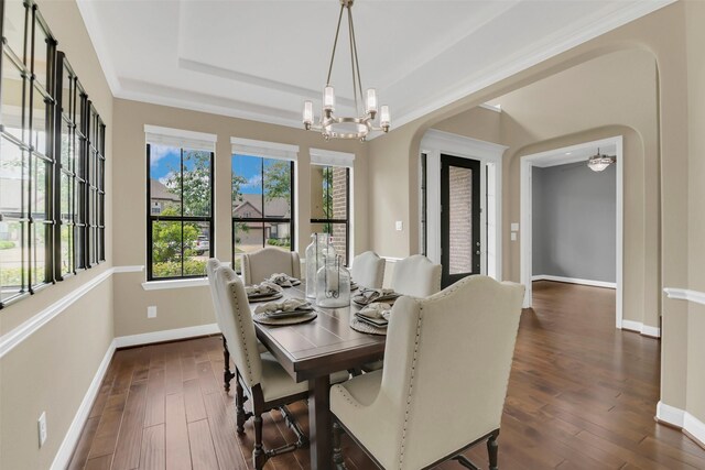 17306 Legend Brook Ct, Tomball, TX 77375 - dining space featuring arched walkways, baseboards, dark wood-style floors, a tray ceiling, and a chandelier