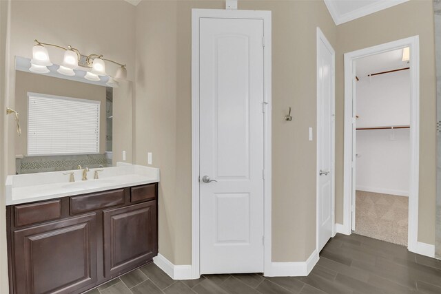 17306 Legend Brook Ct, Tomball, TX 77375 - bathroom with vanity, crown molding, baseboards, a walk in closet, and wood finished floors