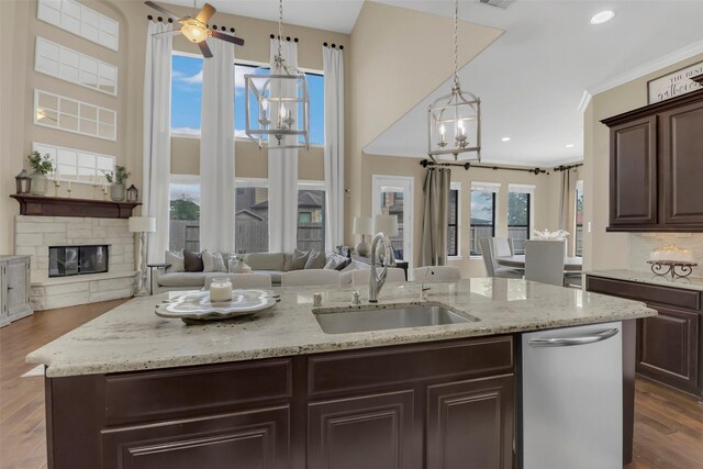 17306 Legend Brook Ct, Tomball, TX 77375 - kitchen with a sink, dishwasher, open floor plan, dark brown cabinetry, and a chandelier