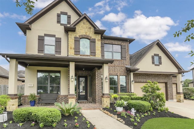 17306 Legend Brook Ct, Tomball, TX 77375 - view of front of home with covered porch, stucco siding, concrete driveway, brick siding, and a garage